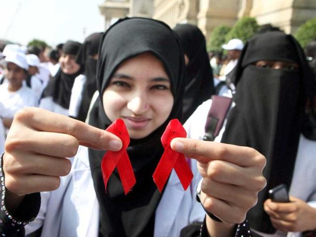 A student holds red ribbons as she participates in an event to mark the World AIDS Day near Vidhan Soudha in Bengaluru. PTI Photo