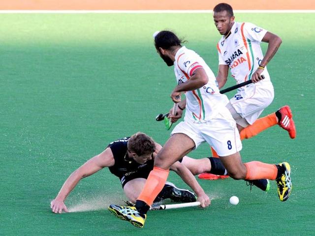Steven Edwards of New Zealand attempts a tackle on India's Sadar Singh (C) during their Pool A match at the Men's Hockey Championships Trophy in Melbourne. (AFP Photo)