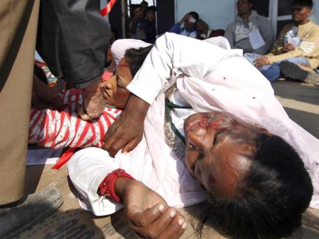 A woman pretends to be dead during a mock drill session at Burari ground, New Delhi. HT/Nadeem Hassan