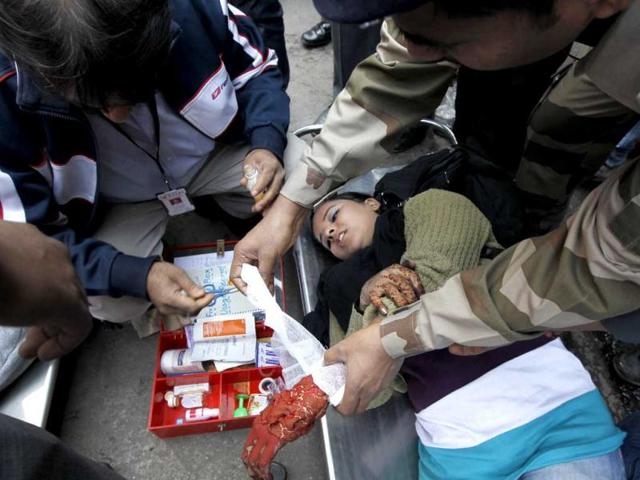 A rescue personnel is seen giving first aid to a woman pretending to be injured during a mock drill session at the Jhandewalan Metro station in New Delhi. HT/Ajay Aggarwal