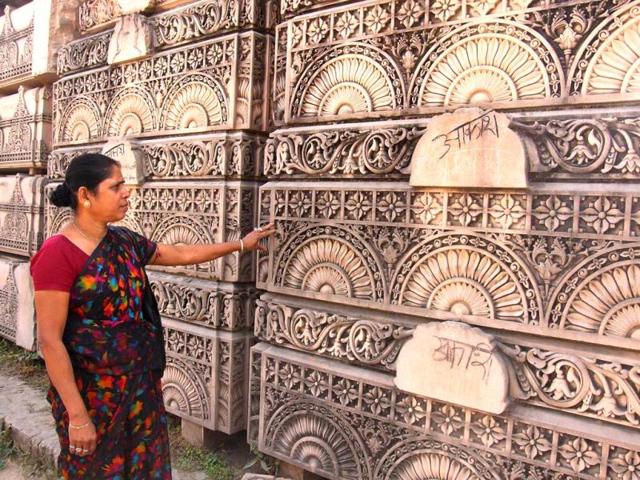 A woman looks at stone slabs earmarked for the construction of a Hindu temple at a workshop in Ayodhya. (AFP Photo)