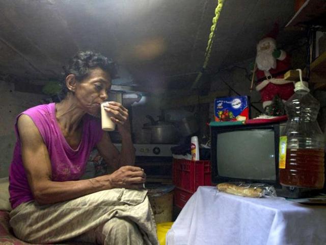 Colombian Maria Garcia drinks coffee inside a sewer in Medellin, Antioquia department, Colombia. Garcia and her husband Miguel Restrepo, 62, are homeless and have lived for more than twenty years in a sewer, near Medellin's downtown. AFP Photo