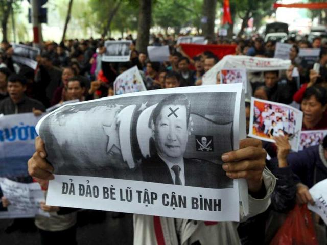 A protester holds a poster with portrait of newly-elected Chinese President Xi Jinping reading "Down with Xi Jinping's gang" during an anti-China rally in downtown Hanoi. About 200 protesters took to Hanoi's streets in the Vietnamese capital amid heightened territorial tensions over the South China Sea. (AFP Photo)