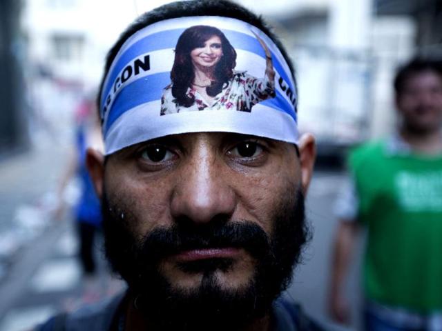 An activist wears a bandana with a photo of Argentine President Cristina Fernandez during a rally to mark the 29th anniversary of the return to democracy in Argentina, on the eve of the Human Rights Day, in Buenos Aires, Argentina. (AP Photo/Victor R. Caivano)