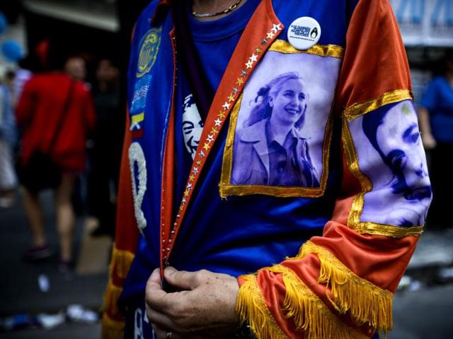 An activist wears a jacket with photos of late revolutionary leader Ernesto "Che" Guevara, right, and Argentina's late first lady Maria Eva Duarte de Peron, known as "Evita," center, during a rally to mark the 29th anniversary of the return to democracy in Argentina, on the eve of the Human Rights Day, in Buenos Aires, Argentina. (AP Photo/Victor R. Caivano)
