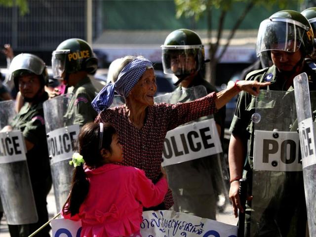 Riot police block residents from the Boeung Kak lake community during their march to celebrate the 64th anniversary of Human Rights Day, in Phnom Penh. Lake residents who are embroiled in land disputes have gathered to celebrate the 64th Human Rights Day and to appeal to Cambodian Prime Minister Hun Sen for help in their threatened eviction from land which is to make way for the development of luxury private property. REUTERS/Samrang Pring