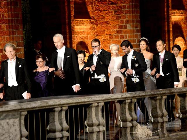 The 2012 Nobel prize laureates arrive with Prince Carl Philip of Sweden (5thR) and Prince Daniel of Sweden (5thL) at the Stockholm Town Hall to attend the Nobel banquet, a traditional dinner after the Nobel Prize awarding ceremony at the Stockholm City Hall. AFP PHOTO/JONATHAN NACKSTRAND