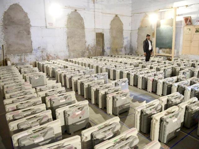An election monitor stands near Electronic Voting Machines at a distribution centre at Viramgam, some 60 kms from Ahmedabad. Elections for the 182-member Gujarat Assembly will be held in two phases on December 13 and 17. AFP Photo