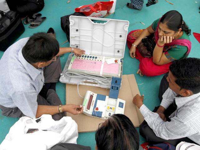 Polling officials check an electronic voting machine at a distribution centre ahead of state assembly polls in Sanand, Gujarat. (Reuters)