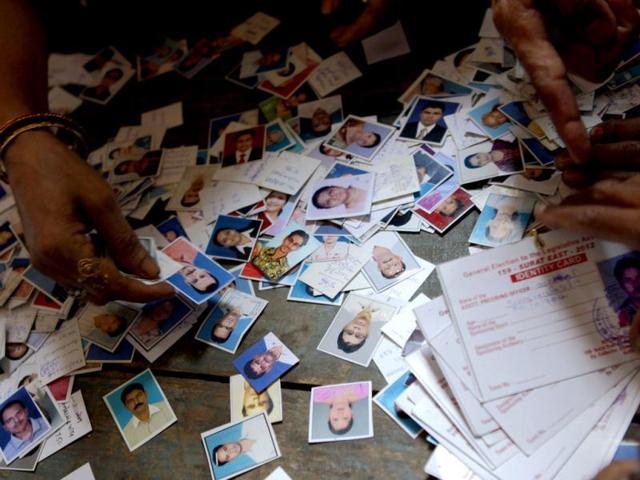 Election monitors check identity cards at a distribution centre in Surat, Gujarat. (HT Photo/Satish Bate)