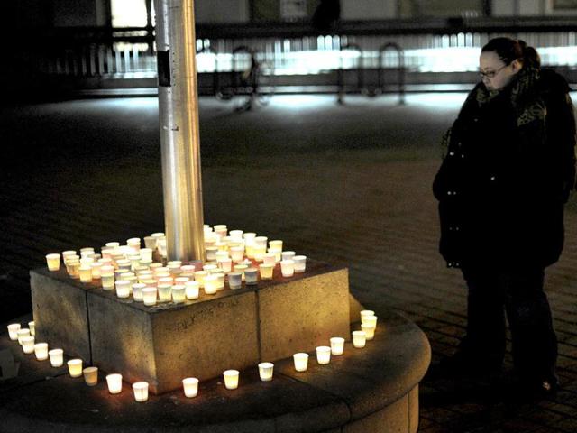 A woman stands near candles commemorating victims of a Connecticut elementary school shooting during a vigil in Oakland, California. Reuters