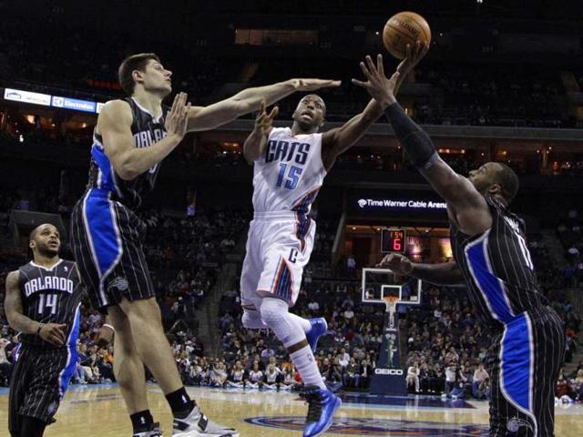 Charlotte Bobcats' Kemba Walker drives between Orlando Magic's Nikola Vucevic, left, and Glen Davis, right, during the second half of an NBA basketball game in Charlotte, N.C. The Magic won 107-98. AP photo