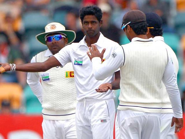 Sri Lanka's Shaminda Eranga, second from left, is congratulated by teammates after bowling Australia's Phil Hughes for 16 runs on the fourth day of their cricket test match at Bellerive Oval in Hobart, Australia. AP Photo