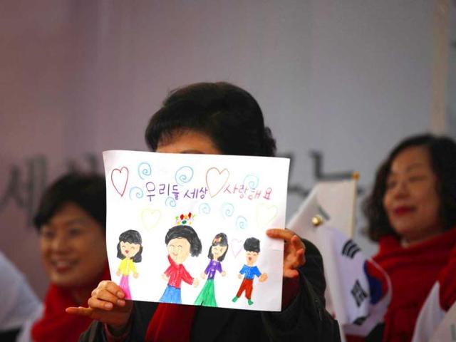 South Korea's presidential candidate Park Geun-hye of ruling Saenuri Party holds a painting drawn by a supporter's child, during her election campaign rally in Cheonan, south of Seoul. The Korean characters in painting reads "I love our world". The country's presidential election will be held on December 19. Reuters