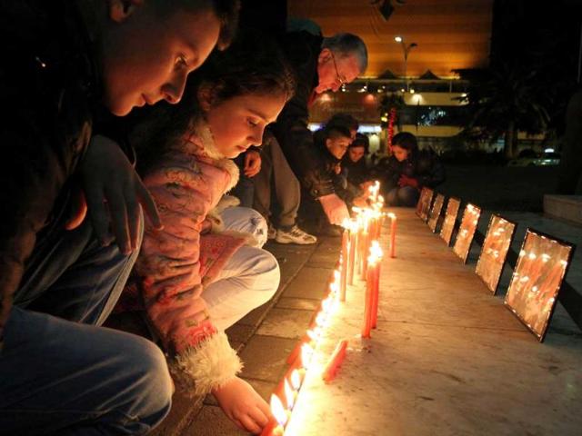 Albanian children light candles as pay their respects at Tirana’s main square, to the victims of an elementary school shooting in Newtown, Connecticut. AFP Photo/Gent Shkullaku