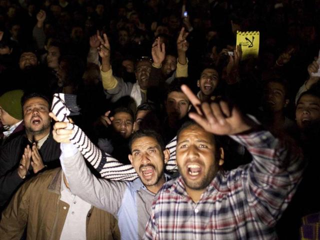 Egyptian protesters opposing president Mohammed Morsi chant slogans while one carries a placard that reads in Arabic "no for the unjust constitution," during a rally in Tahrir Square, Cairo, Egypt. AP photo