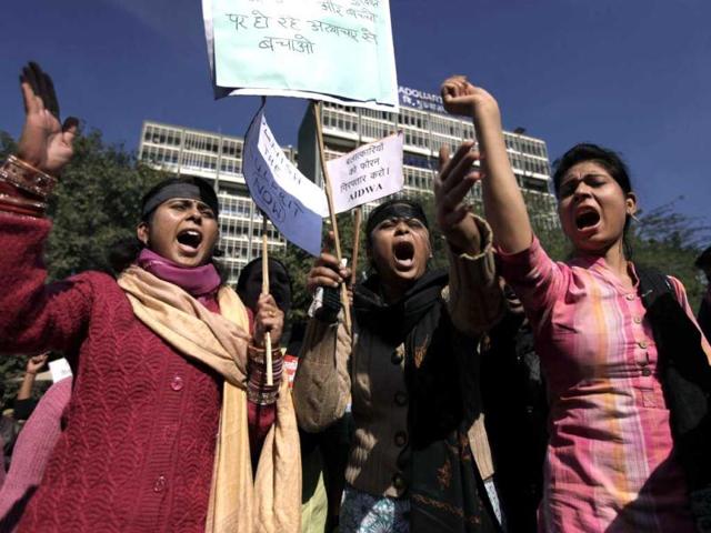 Women shout slogans outside the Delhi Police HQs as they block main road during a protest. The Sunday gang-rape and near fatal beating of a 23-year-old student on a bus triggered outrage and anger across the country as people demanded action from authorities. The placard at center right reads "Arrest the Culprits." (AP Photo)