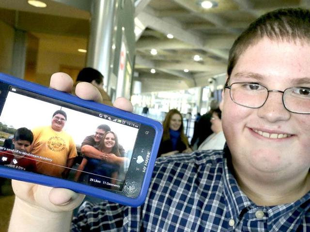 Sixteen-year-old Jason Alexander shows a photo of himself taken four months ago when he left for a weight-loss boarding school at the Kansas City International Airport in Kansas City. AP Photo