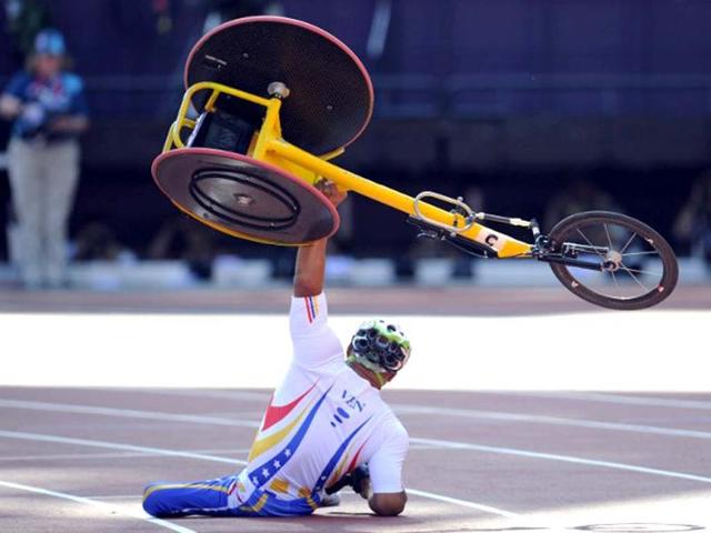 Venezuela's Jesus Aguilar raises his wheelchair after crashing just before the finish line during the men's 800m T53 round 1 during the athletics competition at the London 2012 Paralympic Games in the Olympic Stadium in east London on September 4, 2012. AFP Photo