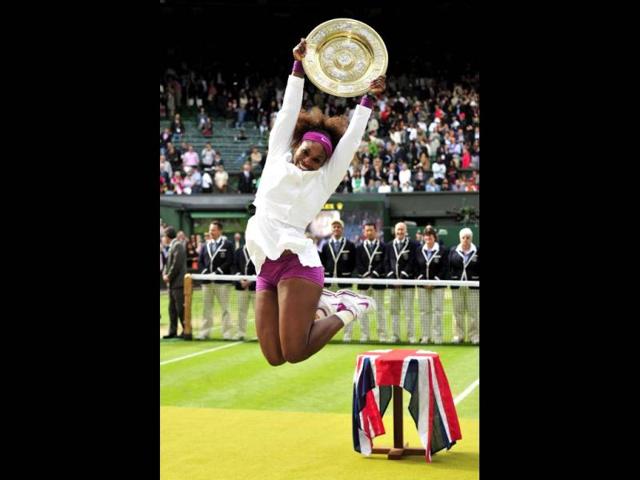 US player Serena Williams celebrates with the trophy, the Venus Rosewater Dish after her women's singles final victory over Poland's Agnieszka Radwanska on day 12 of the 2012 Wimbledon Championships tennis tournament at the All England Tennis Club in Wimbledon, southwest London, on July 7, 2012. Serena Williams won the match 6-1, 5-7, 6-2. AFP Photo