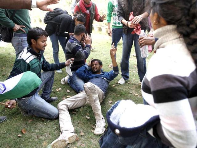 People surround an injured demonstrator at India Gate during a protest that turned violent. Sanjeev Verma/ HT