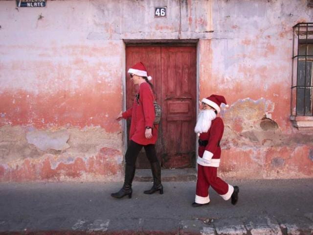 Alexander, dressed as Santa Claus, walks beside his mother in Antigua, about 42 km (26 miles) of Guatemala City. Reuters Photo
