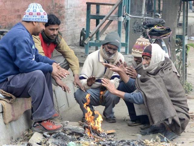 Labourers warm themselves around a bonfire at a roadside in Amritsar. AFP Photo