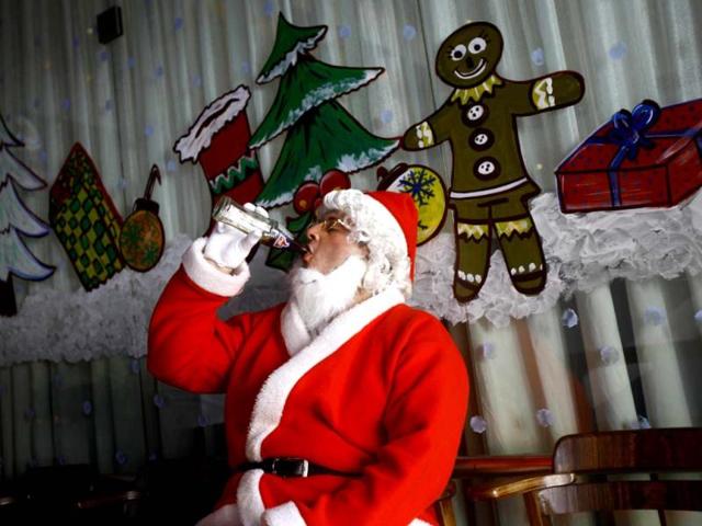 A man dressed as Santa drinks cola as he waits to take part in a Christmas celebration in Mumbai. Although Christians comprise only 2% of the population, Christmas is a national holiday in the country. (AP Photo)