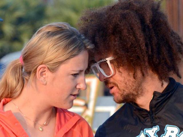 World number one woman's tennis player Victoria Azarenka of Belarus (L) and her boyfriend, US rapper Redfoo (R), chat as they meet with Buddhist monks at a hotel in Thailand's resort seaside town of Hua Hin. (AFP Photo)