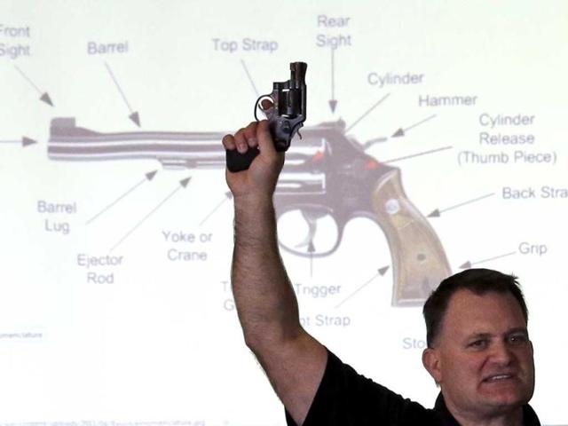Clark Aposhian, President of Utah Shooting Sport Council, holds a pistol during concealed weapons training for 200 Utah teachers in West Valley City, Utah.(AP Photo)