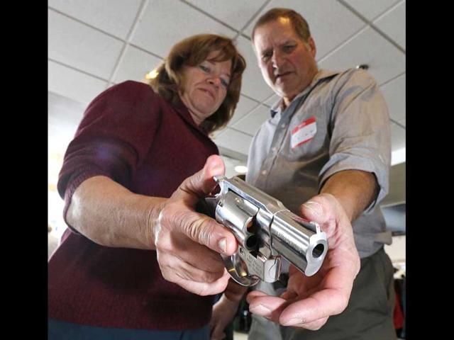 A Utah teacher is shown how to handle a handgun by instructor Clint Simon (R), at a concealed-weapons training class to 200 Utah teachers in West Valley City, Utah. (AFP Photo)