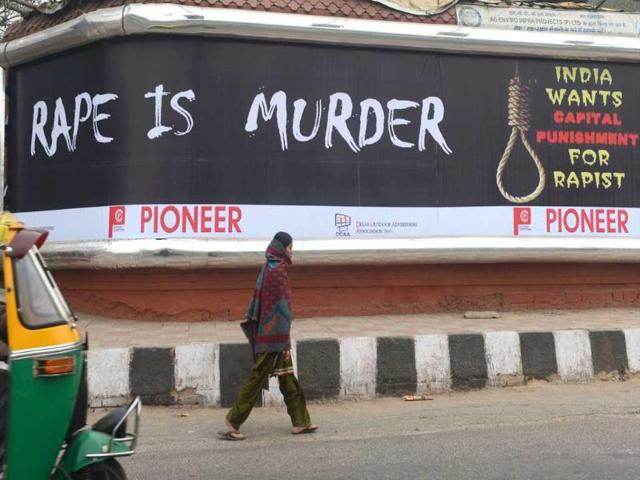 A-woman-walks-past-a-billboard-calling-for-capital-punishment-against-rape-in-New-Delhi-AFP-Raveendran