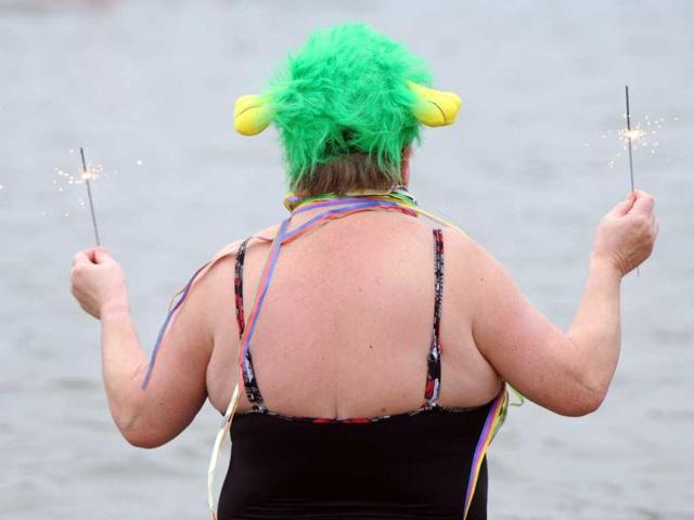 A winter bather of the "Berlin Seals" holds sparklers at the Orankesee lake during a New Year's swimming event on in Berlin. AFP Photo