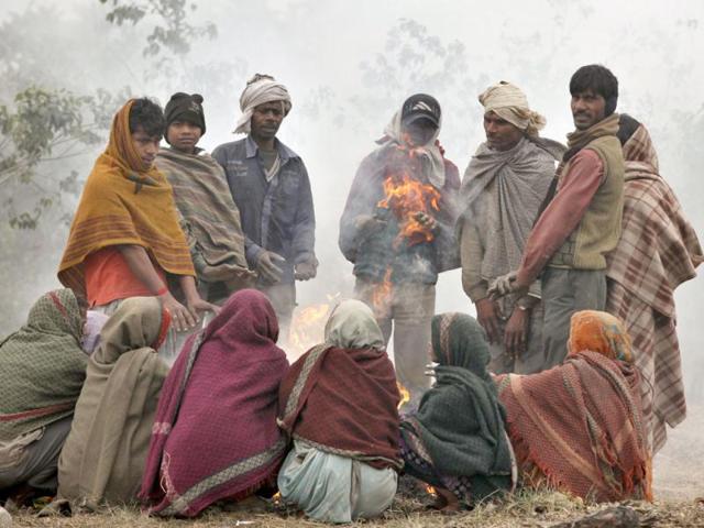 People sit around a bonfire to keep themselves warm in New Delhi's Mayur Vihar area. HT/Raj K Raj