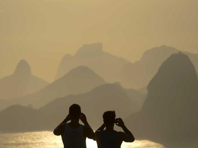 People photograph the sunset in Rio de Janeiro, Brazil, Sunday. (AP Photo)