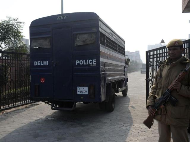 Indian police personnel look on as a vehicle, which is believed to be carrying the accused in the Delhi gangrape and murder case, arrives at an entrance to Saket district court in New Delhi. (AFP Photo)