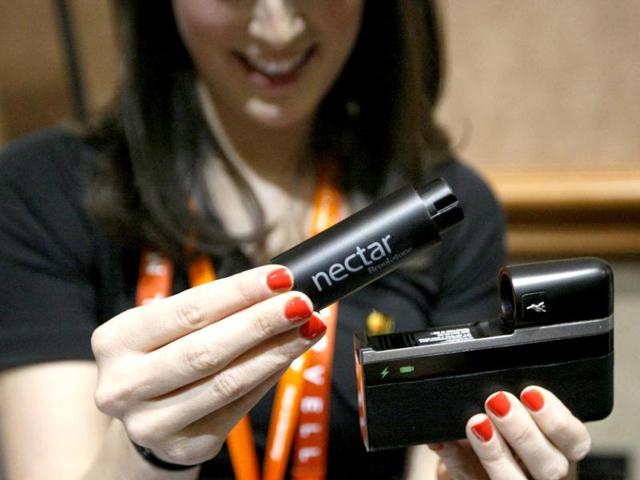 A woman demonstrates the Nectar mobile power source at the CES, world's largest technology conference in Las Vegas. The device will charge and power a mobile device for up to two weeks. (Reuters)