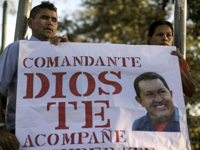 A Salvadorean couple holds a sign during a religious ceremony for Venezuelan President Hugo Chavez's health called by members of the Farabundo Marti National Liberation Front (FMLN) at the Simon Bolivar Park in San Salvador. (AFP Photo)