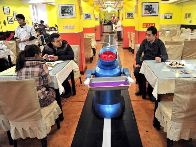 A robot that specialises in delivering food holds an empty plate after serving meals to customers at a Robot Restaurant in Harbin. Reuters Photo