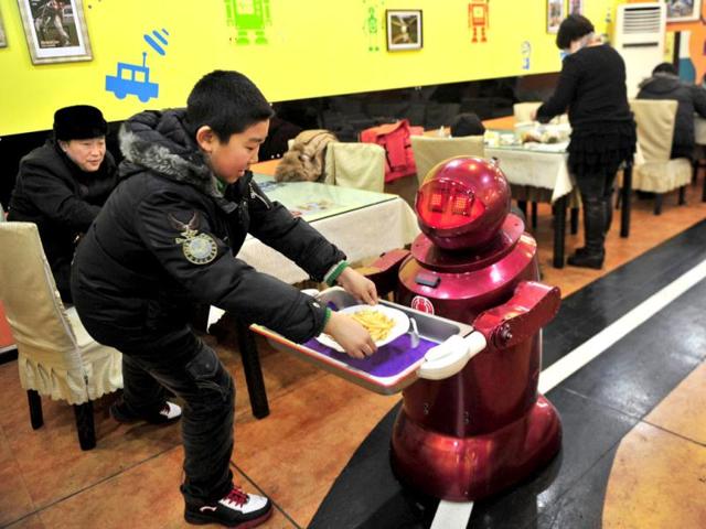 A robot that specialises in delivering food serves a customer with french fries at a Robot Restaurant in Harbin. Reuters Photo