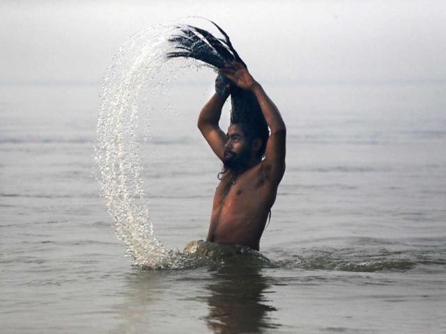A Naga sadhu, swings his head as he bathes at Sangam, the confluence of the rivers Ganges, Yamuna and mythical Saraswati. AP/Kevin Frayer
