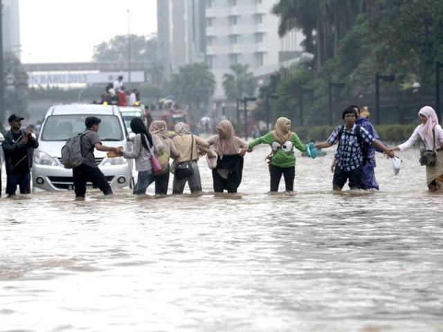 Indonesian workers cross a flooded street at the business district in Jakarta. Heavy rains triggered severe flooding in large parts of the Indonesian capital Jakarta forcing many government offices and businesses to close. (Reuters)