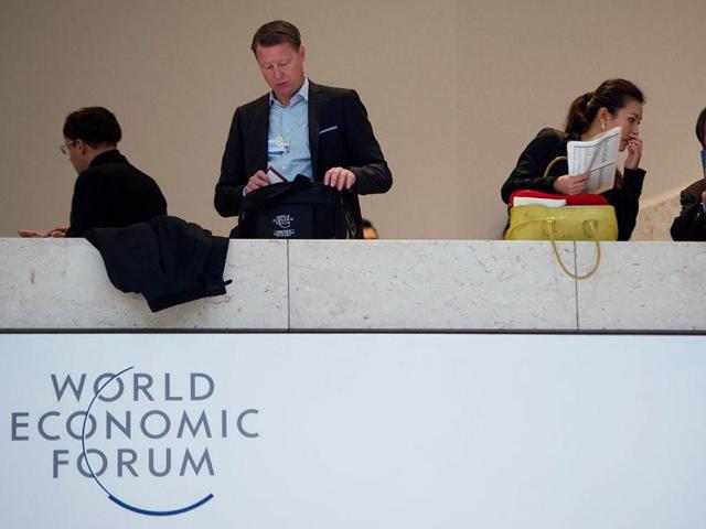 A man stands next to a 'World Economic Forum' logo during the 2013 World Economic Forum Annual Meeting at the Swiss resort of Davos. AFP photo