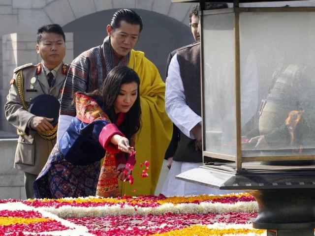 Bhutan's Queen Jetsun Pema scatters rose petals at the Mahatma Gandhi memorial as King Jigme Khesar Namgyel Wangchuck watches at Rajghat in New Delhi. Reuters