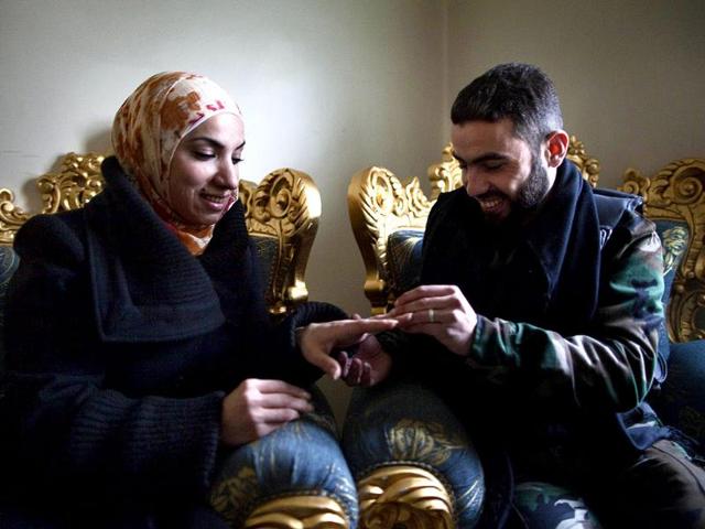 Yusef-puts-a-wedding-ring-on-his-fiancee-Ghada-s-finger-in-the-Sukkari-district-of-Aleppo-in-northern-Syria-AFP-JM-Lopez Yusef-puts-a-wedding-ring-on-his-fiancee-Ghada-s-finger-in-the-Sukkari-district-of-Aleppo-in-northern-Syria-AFP-JM-Lopez