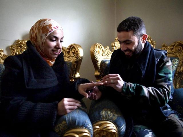 Yusef-puts-a-wedding-ring-on-his-fiancee-Ghada-s-finger-in-the-Sukkari-district-of-Aleppo-in-northern-Syria-AFP-JM-Lopez