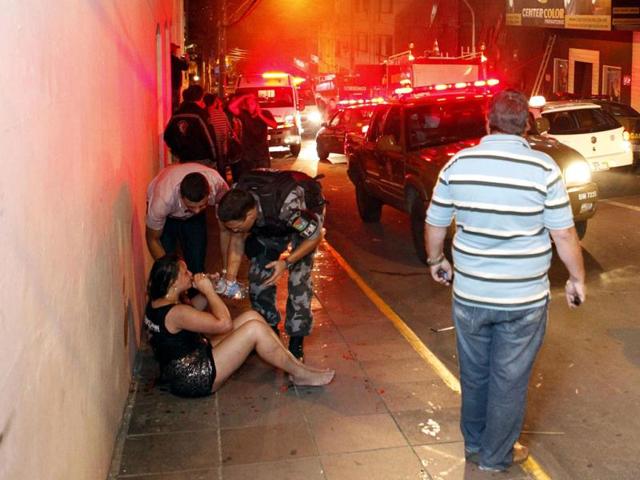 A police officer helps a woman next to Kiss nightclub in the southern city of Santa Maria, Brazil. At least 232 people were killed in the nightclub fire that broke while a band was performing. (Reuters)