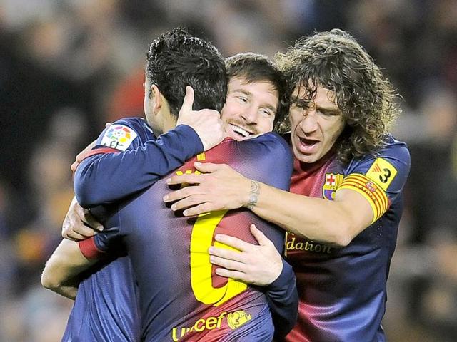Barcelona's Lionel Messi from Argentina, left, celebrates with his fellow teammates Carles Puyol, right, and Xavi Hernandez after scoring against Osasuna during their Spanish League soccer match, at Camp Nou stadium in Barcelona, Spain. Barcelona won the match 5-1. AP Photo