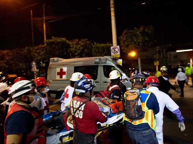 Rescue workers and firefighters assist an injured person after an explosion at an adjacent building to the executive tower of Mexico's state-owned oil company Pemex, in Mexico City. AP/Eduardo Verdugo