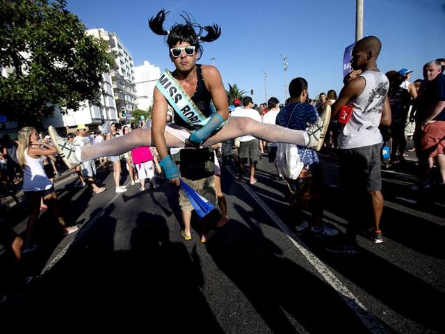 A reveler performs a split jump at the Simpatia e Quase Amor or "Kindness is almost love," block party, a pre-Carnival celebrations in Rio de Janeiro, Brazil. AP/Silvia Izquierdo